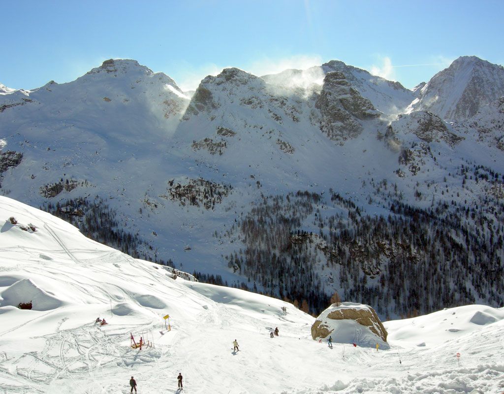 Il vento con la neve fresca crea le nuvole di neve sulle vette