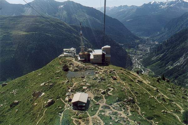 Sulla funivia che in una sola campata raggiunge il Rifugio Torino. Sotto di noi il giardino botanico Saussurea, sullo sfondo Courmayeur.