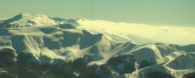 In lontananza il comprensorio del Corno alle Scale e, tra le nubi, svetta la cuspide del monte Cupolino, che sovrasta il Lago Scaffaiolo.