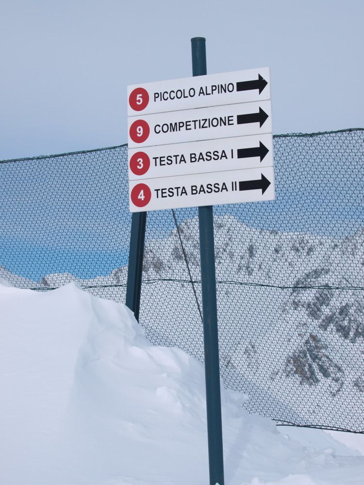 Dai 2450 metri partono anche le piste rosse che riportano alla partenza della seggiovia Testa Bassa; proseguendo verso est si incontra la rossa Piccolo Alpino.