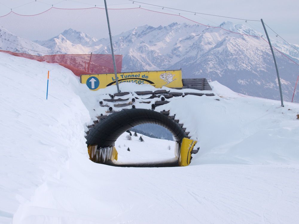 Il tunnel dove la Marmotte passa sotto la Testa Bassa 2.
Le piste rosse tracciate sul versante della seggiovia Testa Bassa hanno caratteristiche abbastanza simili;  larghe e ben battute con molti cambi di pendenza.
