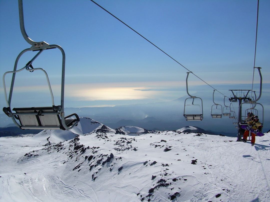 Nella foto, scattata dalla seggiovia dell'impianto di Etna Sud, si vedono i crateri spenti e la magnifica costa Catanese fino alla città di Augusta con il sole che rispecchia nelle acque dello ionio.