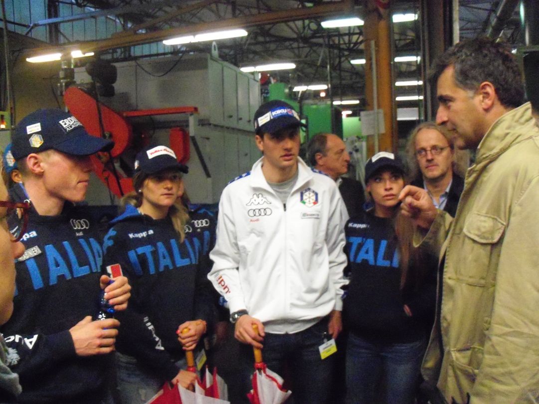 Lukas Hofer, Nicole Gontier, Dominik Windisch e Dorothea Wierer ascoltano le spiegazioni del direttore tecnico dell'azienda Costantino Fiocchi